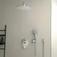 Moderne Dusche mit einer großen, runden Kopfbrause und einem Handbrause-Set von Ideal Standard. An der Wand montiert, kombiniert mit einem schlichten Bedienfeld.